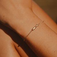 Bracelet Poisson en plaqué or, porté au poignet en gros plan